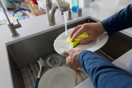 Close-up of a Man Washing Dishes in a Sink at Home