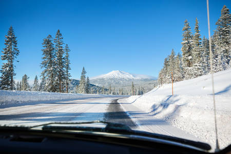 View from a Car Driving Through a Snowy Landscape with Mt. Bachelor in the Background