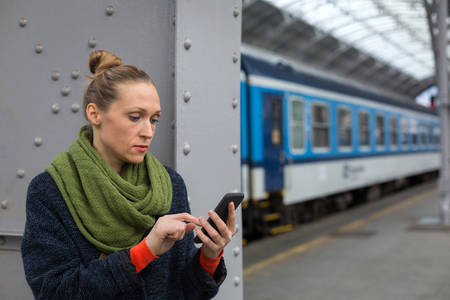 Woman with a Cell Phone on a Railroad Station Platform