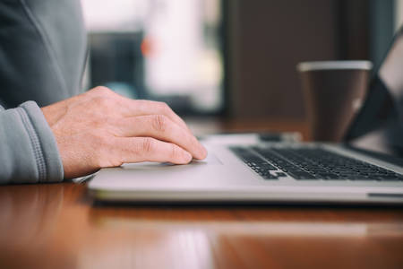 Low-Angle View of a Man's Hand on a Laptop Keyboard
