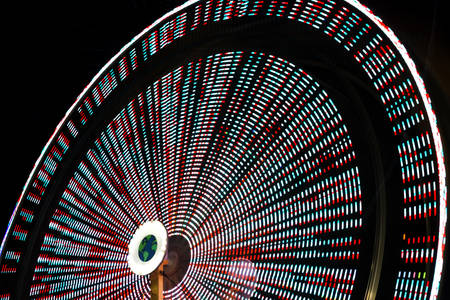 Blurred Motion of a Colorful Ferris Wheel at a County Fair at Night 