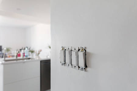 Electrical Light Switch Set without a Plate on a White Wall