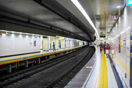 Interior of a Tokyo Subway Station with Commuters on a Train Platform