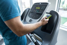 Man Standing on a Treadmill in a Gym and Checking His Cell Phone Man Standing on a Treadmill in a Gym and Checking His Cell Phone
