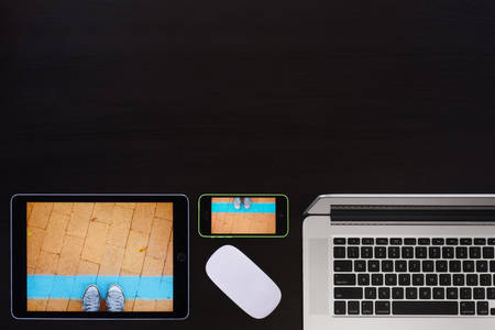 Symmetrically Arranged Workspace with Digital Devices on a Black Background