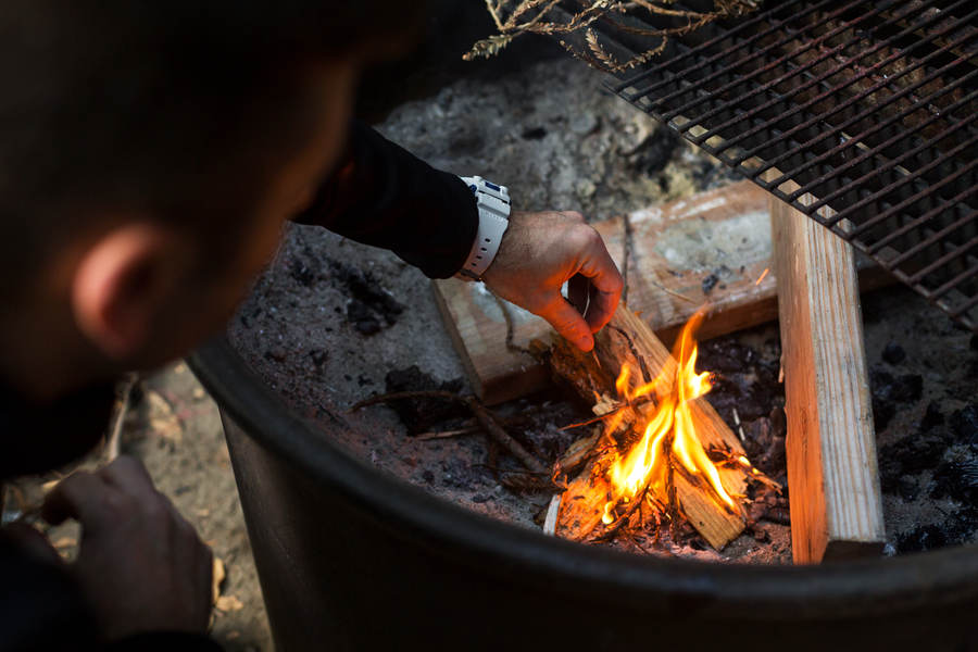 Outdoorsy Man Starting Fire in Stock Photo - PixelTote