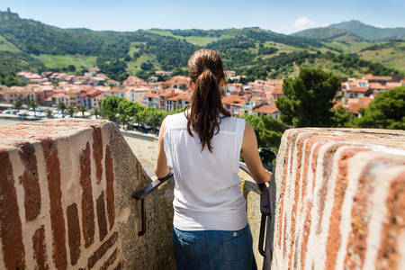 Rear View of a Woman Looking out from a Wall of a Historic Castle in Southern France
