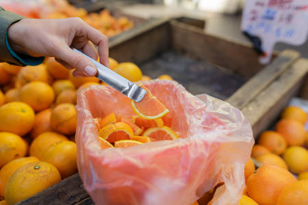 Woman Trying an Orange Sample at a Farmers Market
