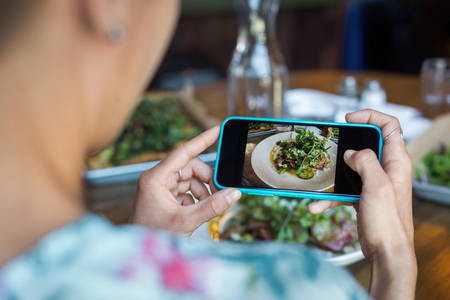 Close-Up of a Woman Taking Picture of Her Meal with a Camera Phone