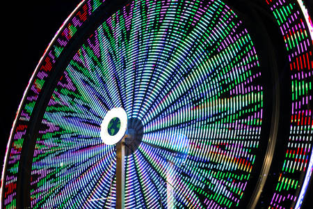 Blurred Motion of a Colorful Ferris Wheel at an Amusement Park at Night 