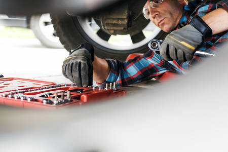 Auto Mechanic Reaching for a Socket When Performing a Car Repair