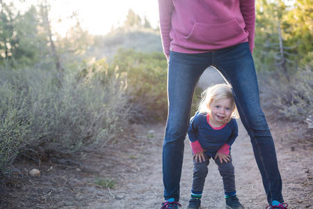 Smiling Toddler Girl Standing with Her Mom on a Trail in Nature