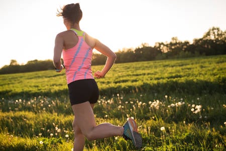 Young Athletic Woman Running Outdoors During Sunset