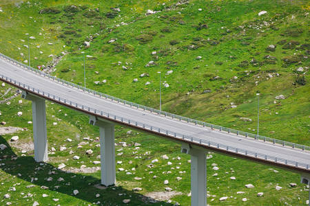 Road Overpass Above a Green Hillside with Dispersed Rocks