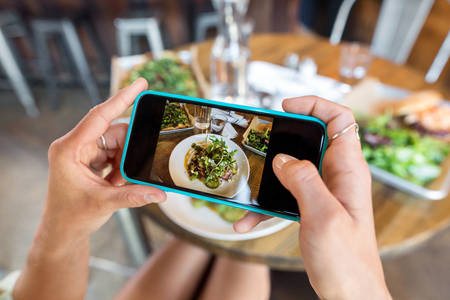  Hands of a Woman Taking a Picture of a Meal with a Cell Phone