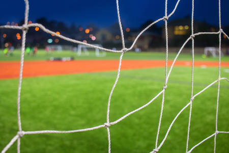 Detailed View of a Soccer Goal Net and Soccer Field at Night